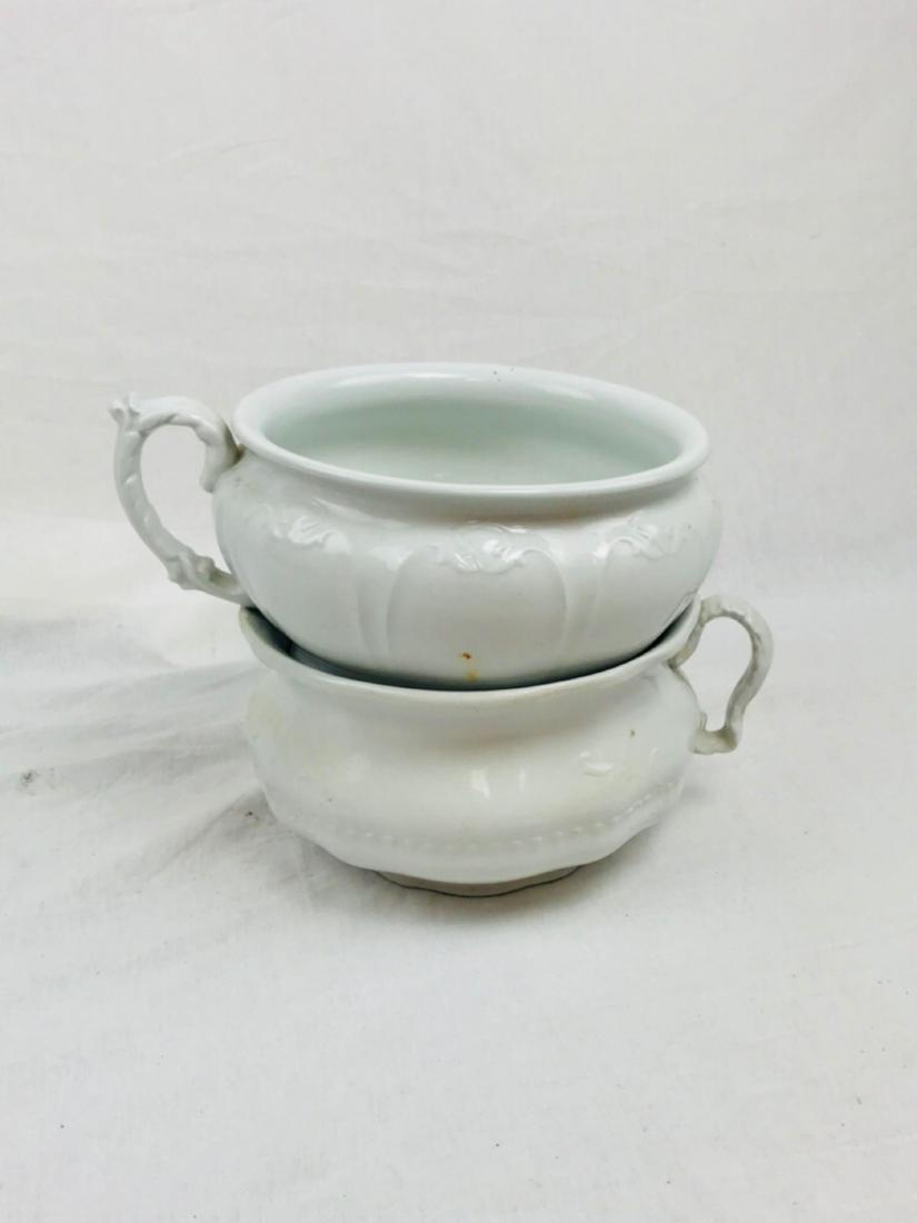 2 Vintage Ironstone Chamber Pots by Johnson Bros.,: 2 Vintage Ironstone Chamber Pots by Johnson Bros., Marked; these two white porcelain pots have an ornate appearance. One shows no chips or blemishes; one shows a chip on the base. Each measures approx