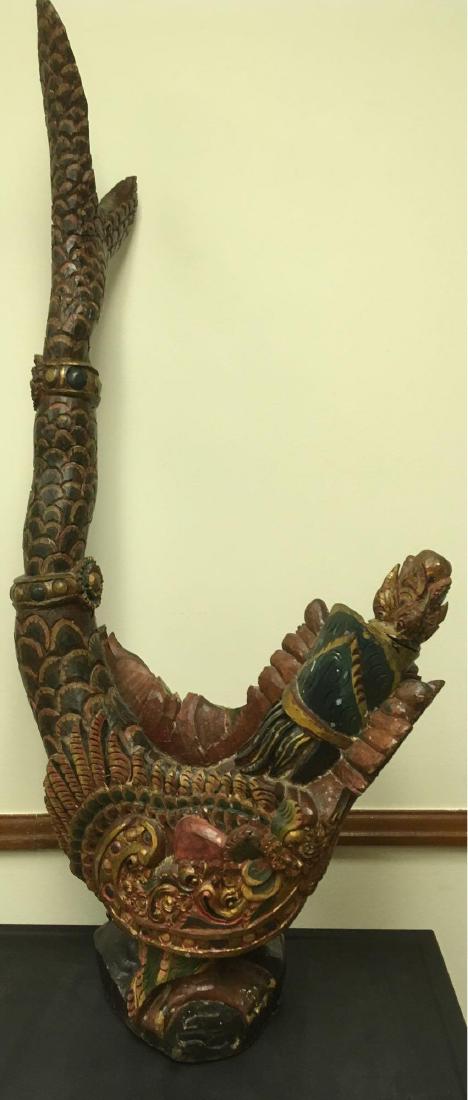 Carved Balinese or East Asian Garuda Bird: This is a nicely carved and colored piece of hardwood.Â There is a long fish-tail, angered showing bird to defend off others. Good used condition for its age. This piece measures approximately 39"x