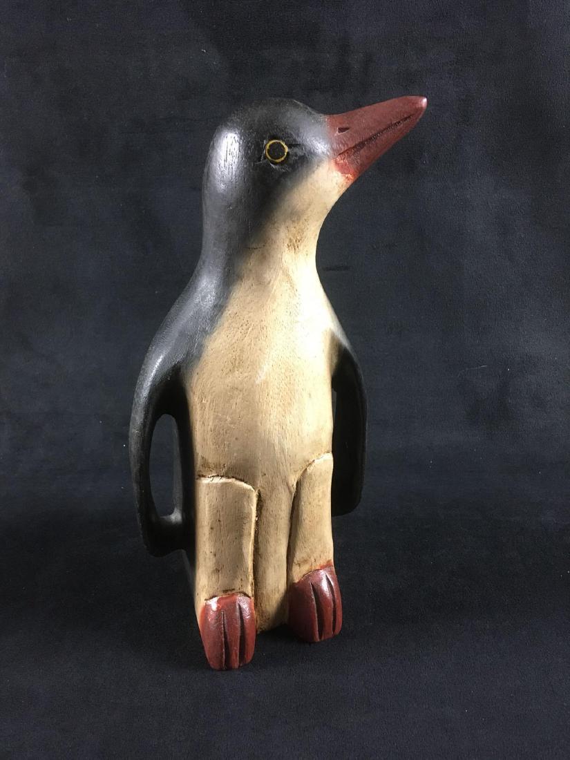 Hand Carved Wooden Penguin Figurine: Hand Carved Wooden Penguin Figurine; this sculpture shows a vintage folk art appearance. The finish is good, we believe the species is Adelie. The penguin measures 5 1/2" W x 5" D x 10 1/2" H.