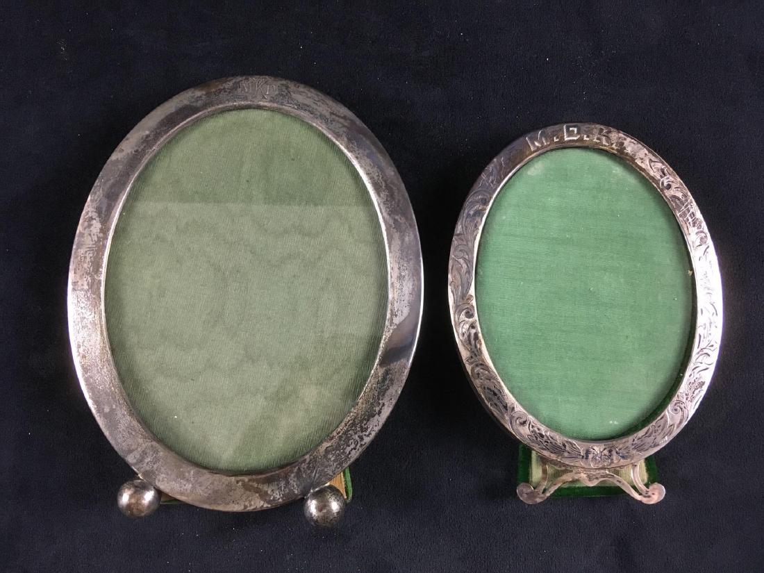 Antique Sterling Silver Picture Frames: Lot of 2 sterling photo frames with green velvet backings. Both are hallmarked and also engraved with MDK. The leg stands are both disconnected. Large 6.3/4" L, 5.1/2" W - Small 5.1/2" L, 4.1/4" W (no