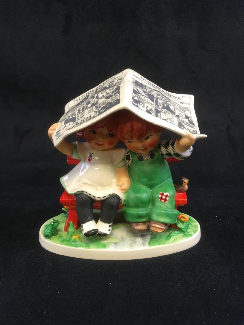 Vintage GoebelÂ Figurine Let it Rain Signed and Marked: Vintage Goebel Figurine Let it Rain, Signed and Marked; a lovely porcelain figurine of two children on a bench seeking cover from the rain. with the Sunday News. The masthead of the paper shows a date