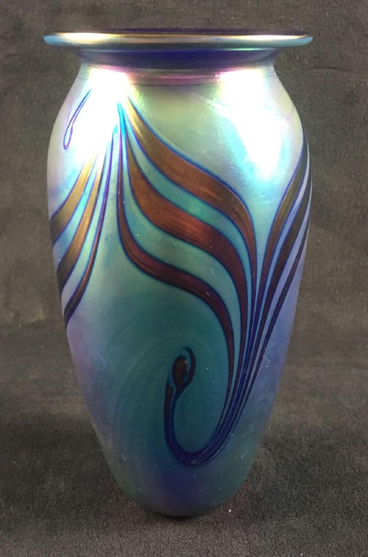 Robert Eickholt Iridescent Art Glass Vase: Robert Eickholt Iridescent Art Glass Vase. This glass vase is in excellent condition. Vase has an abstract design and measures 6.5". Vase was created in 1992 and is signed on the base by the artist. R