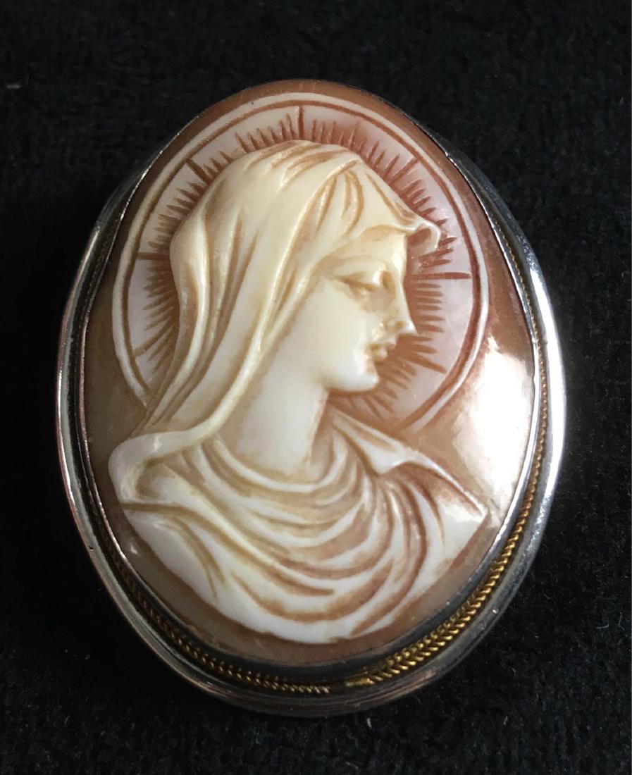 Vintage Mother Mary Cameo Pendant Brooch: Vintage Cameo Pendant Brooch; This cameo pendant is made of seashell, possibly coral, andÂ set in a silver toned oval brooch. It measures at approximately 1 1/2" L x 1 1/4" W.Â