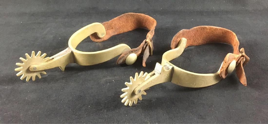 Pair of Vintage EngravedÂ Spurs with Leathers by: Pair of Vintage Engraved Spurs with Leathers by Ricardo Metal; these nickle bronze spurs show engraving on the button and yoke. They are in very good condition, the leathers are sweat stained but