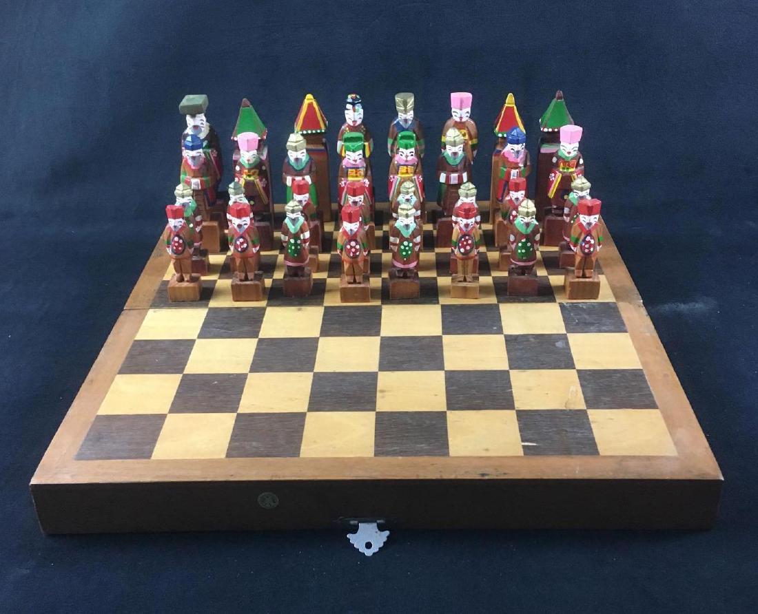 Korean Hand Carved Chess Set: Korean Hand Carved Chess Set. This set is in good condition. It contains all of the chess pieces. The chess pieces depict figures in traditional Korean garb. The pieces are divided into pink and green