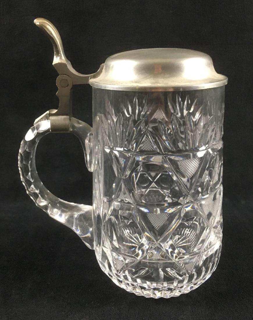 Cut Crystal Lidded Stein: Cut Crystal Lidded Stein. This cut crystal stein is in great condition. The crystal has a star and fan geometric pattern. Stein has a pewter lid. The stein measures 6.5" H and 4" in diameter at the ba