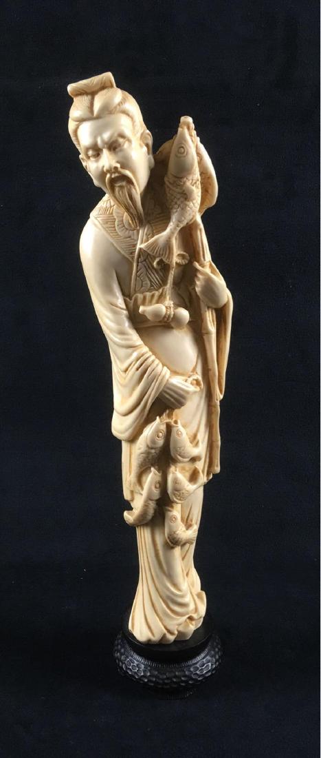 Chinese Resin Carved Fishing Figurine: Chinese Resin Carved Fishing Figurine. This figurine is in excellent condition. This figurine features a detailed carving of a man with a fishing pole and fish on a string. On the bottom are carved ou