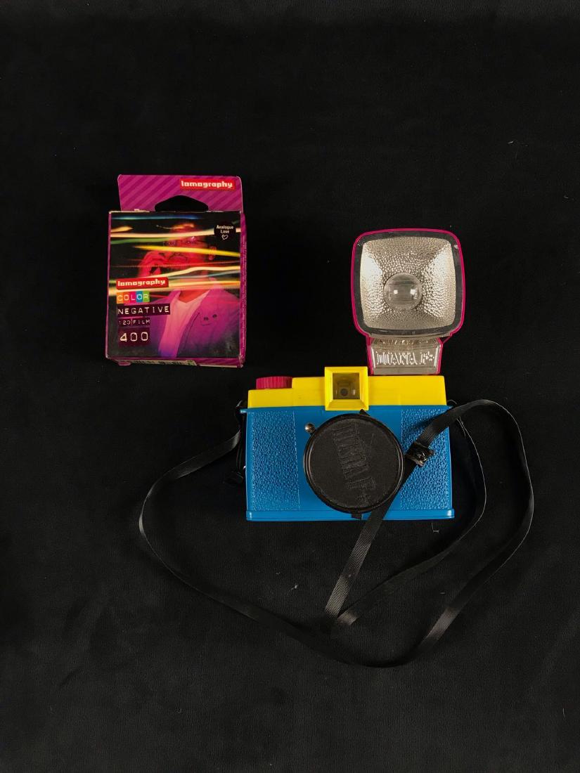 Retro Diana Medium Format Camera: Retro Diana Medium Format Camera; In excellent condition. Includes 2 rolls of color film (there may be an unused roll in the camera), a flash, lens cap, and the Diana Camera coffee table art book. The