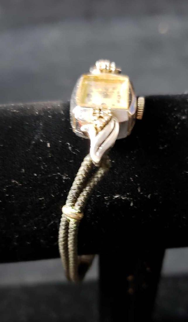 Longines Watch: Longines Watch. This watch is in good condition. The watch has some wear from use. The watch case is 14k gold. There are rhinestones surrounding the watch face. Watch measures approx. 3" in length. We