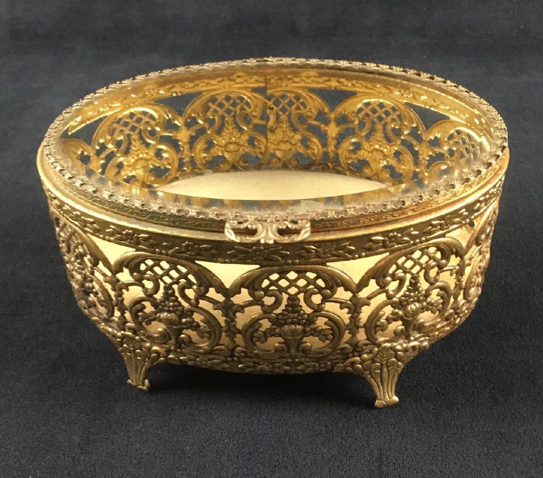 Gold Footed Jewelry or Trinket Box: Gold Footed Jewelry or Trinket Box. This jewelry box is in good condition. The box needs to be polished because it has some tarnishing. It has a glass top which is undamaged. The box measures 6" L x 4