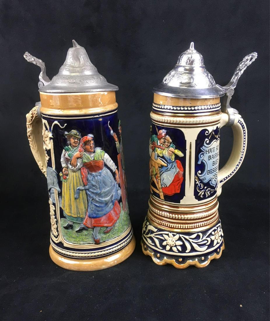 Two Vintage German Beer Steins with Pewter Lids: Two Vintage German Beer Steins with Pewter Lids; both are in very good condition. One shows a social scene of a man and a women and states something akin to "glad with beer that we love". It is marked