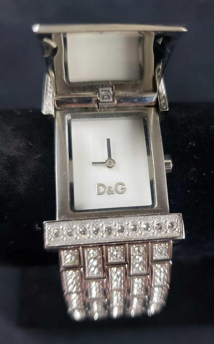 Dolce and Gabbana Time Stainless Steel Watch: Dolce and Gabbana Time Stainless Steel Watch. This watch is in great used condition. The watch has some very light signs of wear and needs a new battery. This watch has an opening face with a pearlesc