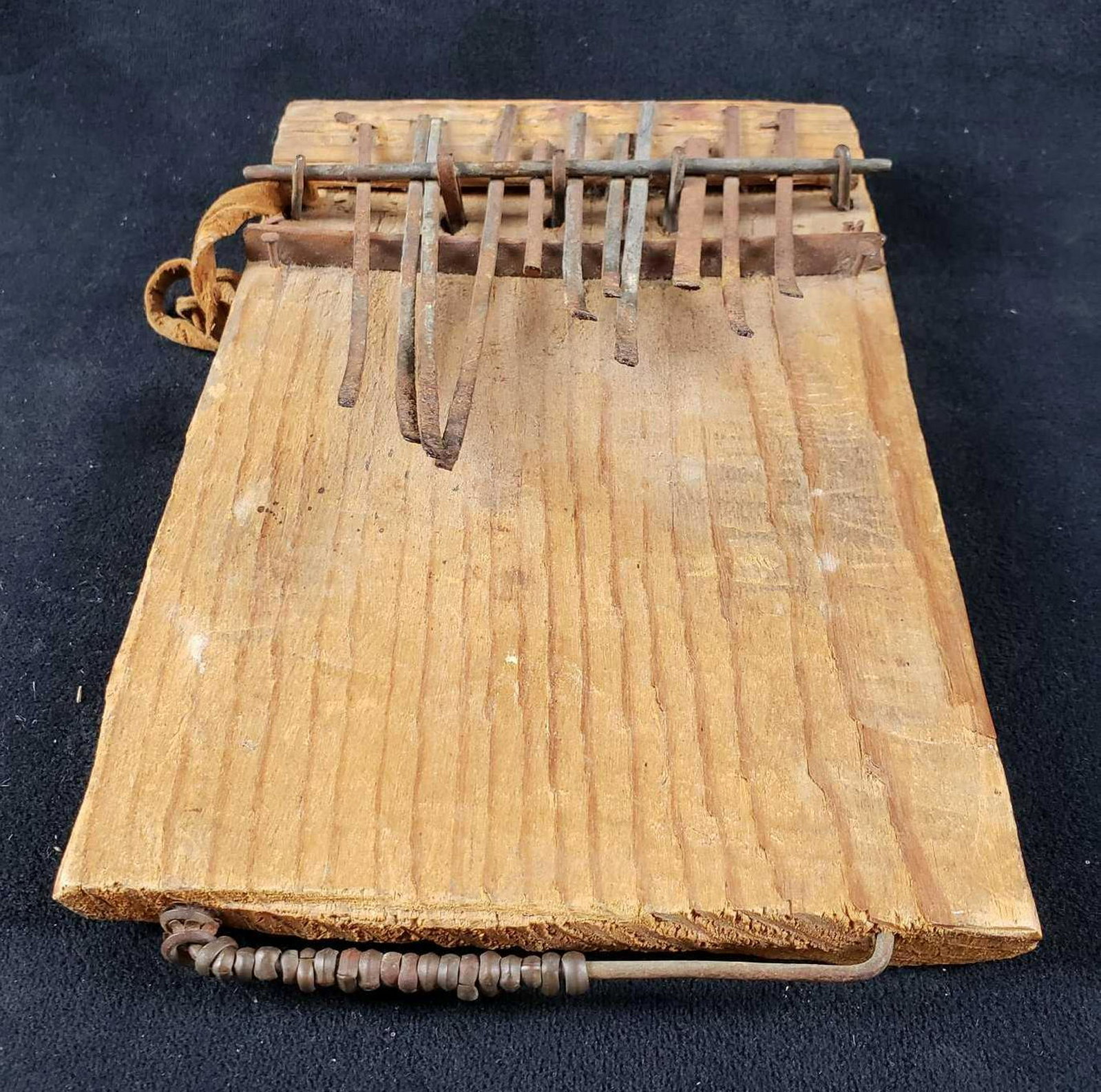 African MbiraÂ Thumb Piano: African Mbira Thumb Piano. This mbira is in good condition. The metal tines are slightly rusty and out of place but it still plays. The bottom has some beads, possibly to make percussive sounds w