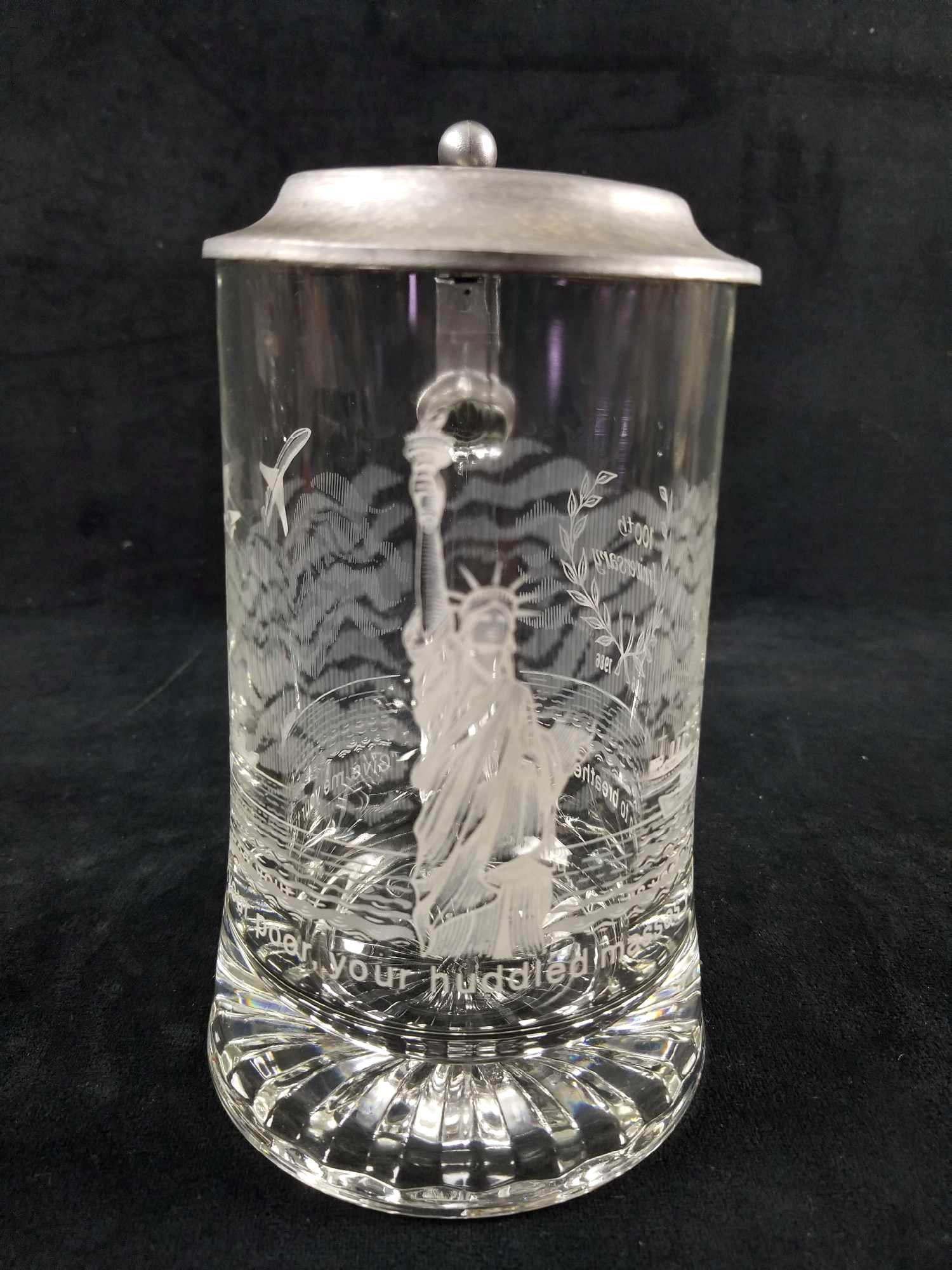 Statue Of Liberty 100th Anniversary Glass Commemorative: This 100tth Anniversary (1886-1986) Commemorative Beer Stein of The Statue of Liberty features beautiful etching of Lady Liberty standing strong with sky detail, boats, and planes out in the distance.