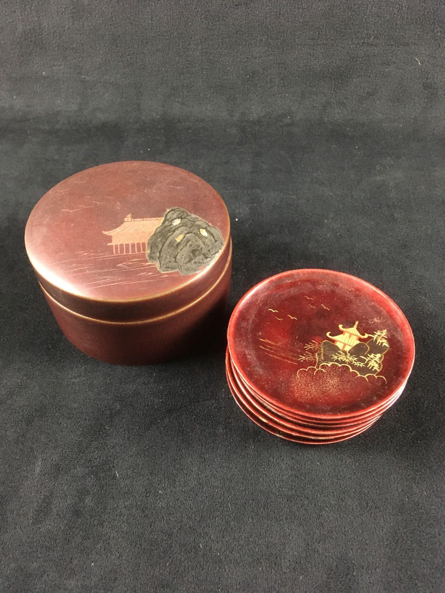 Vintage Set of 6 Japanese Lacquer ware Tea Coasters in: Vintage Set of 6 Japanese Lacquer-ware Tea Coasters in Lacquer-ware Box; the tea coasters show a pagoda scene. The coasters are in very good condition. The round lacquered box shows a tea house scene.