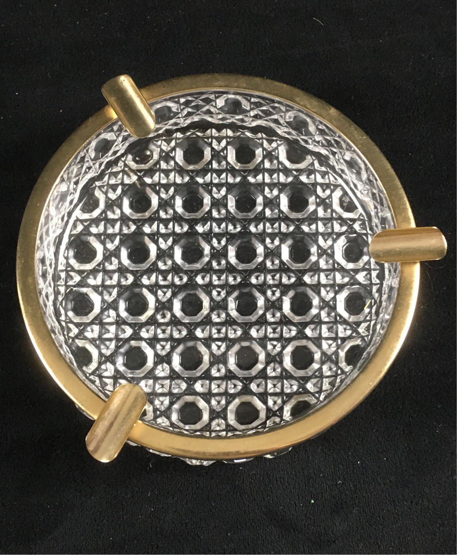 Vintage Molded Glass Ashtray: Molded glass ashtray in the style of crystal with a brass rim. It is in perfect condition. Item measures 1.1/4" tall, 4.3/4 in diameter.Â
