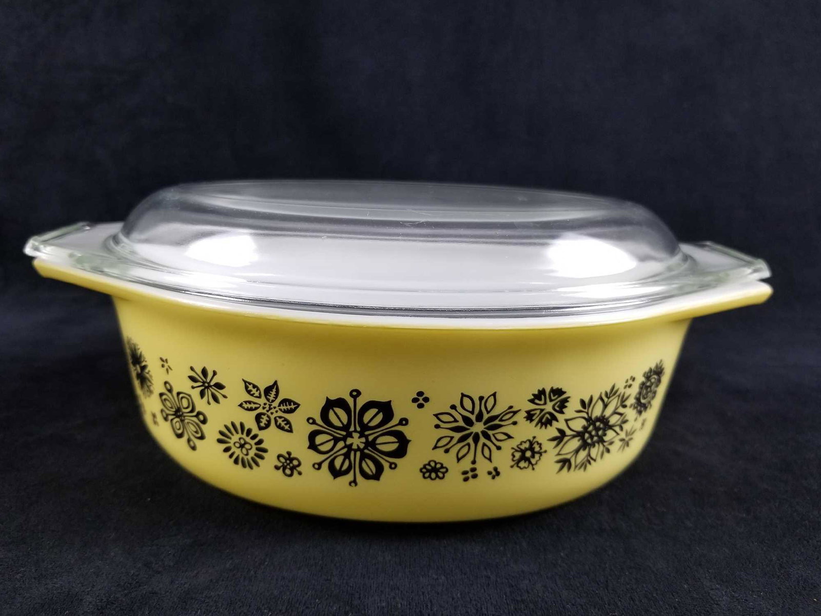 Vintage PYREX Casserole Dish with Floral Design: Vintage PYREX Casserole Dish with Floral Design. This 1 1/2 QT yellow dish with lid displays a black floral design and has some expected scuffing from ware and use on the edges (see images) however th