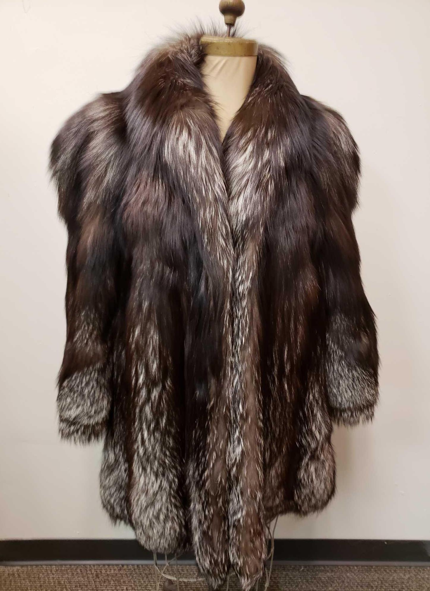 Silver Fox Fur Coat: Silver Fox Fur Coat. This fur coat is in great used condition. There is no known damage to the interior or exterior of the coat. The coat has a brown fabric interior with a paisley pattern. The coat h