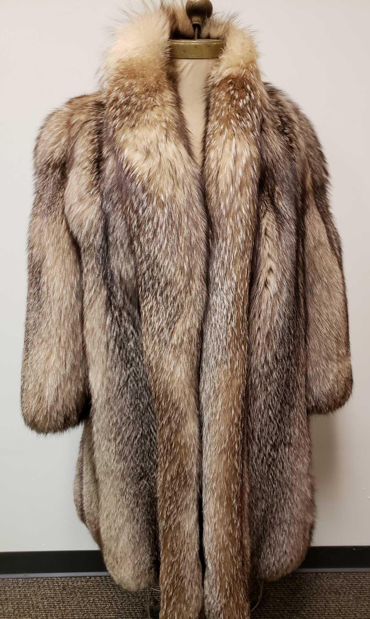 Mid Length Gray Fox Fur Coat: Mid Length Gray Fox Fur Coat. This coat is in great used condition. The coat has no known signs of damage to the interior or exterior. The coat has a light brown fabric lining. Coat has a hook and loo