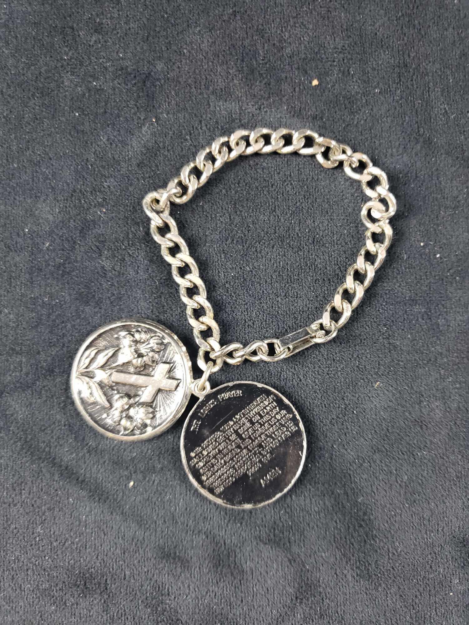 Bracelet with Cross Locket and Lord's Prayer Inside: Bracelet with Cross Locket and Lord's Prayer Inside. This bracelet and locket are in good condition. Bracelet has a heavy silvertone chain and locket with an embossed cross on it. The locket slides op