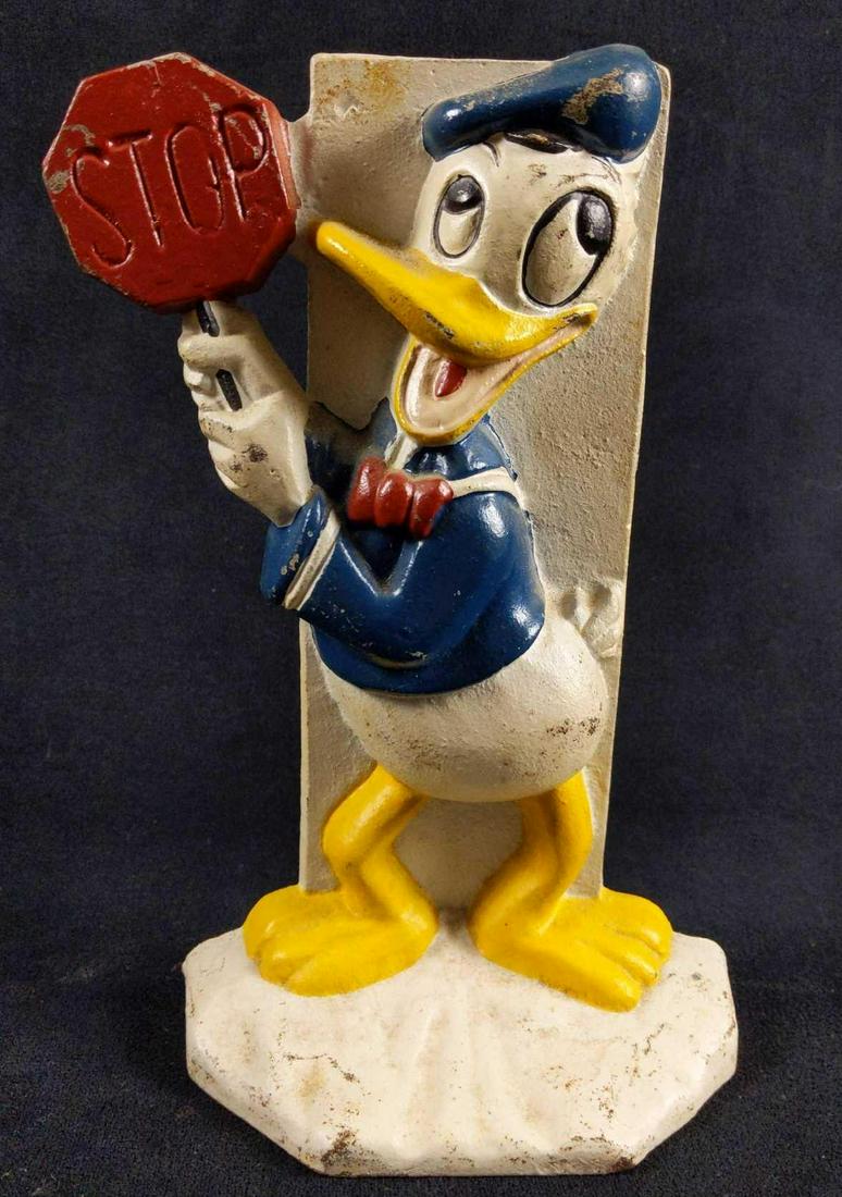 Cast Iron Donald Duck Vintage Door Stopper: Cast iron vintage Donald Duck holding a STOP sign Door Stopper.Â It can also be used as a book end since its very heavy. Great piece of Disney memorabilia! This item is in used condition and has som