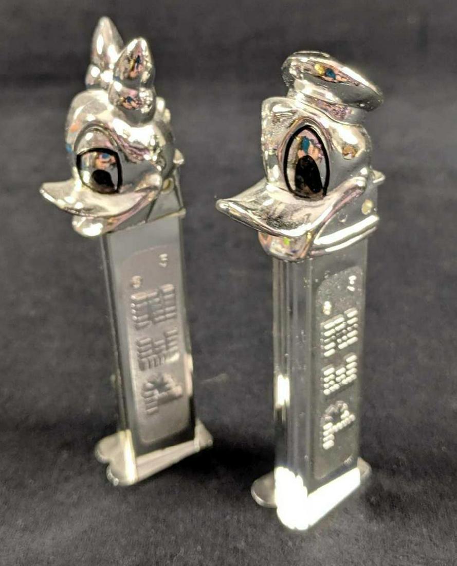Rare Disney Donald And Daisy Duck Chrome Pez Dispensers: This is for a lot of two silver/chrome colored PEZÂ dispensers. EachÂ dispenser is approx 1" x 1" x 5" and is in good, used condition with no noticeable scratches or scuffs. They're both ready to