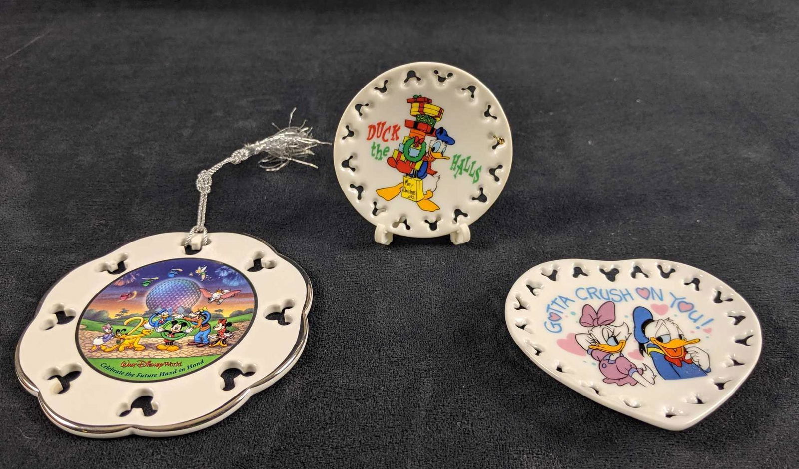 Disney Ornament And Plate Lot: Lot includes:Â Walt Disney World Epcot 2000 "Celebrate the Future Hand in Hand" Tree Ornament. And two holiday mini ceramic plates. One Valentine's Day heart dish "Gotta Crush On You" and one mini C