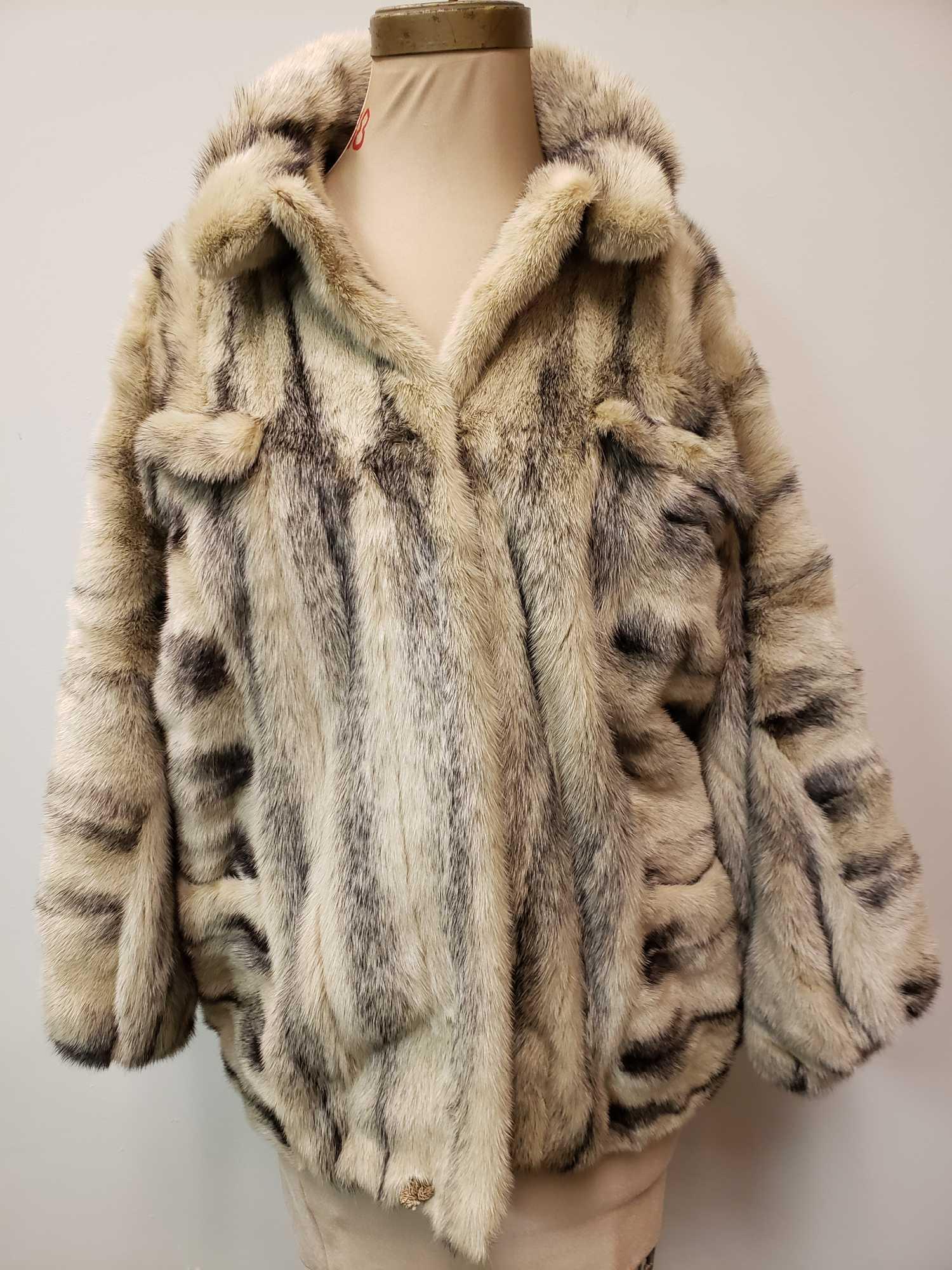 Mid Length Black Cross Mink Fur Coat: Mid Length Black Cross Mink Fur Coat. This fur coat is in great used condition. The coat has no known signs of damage to the interior or exterior. The coat has a tan colored fabric interior. At the fr