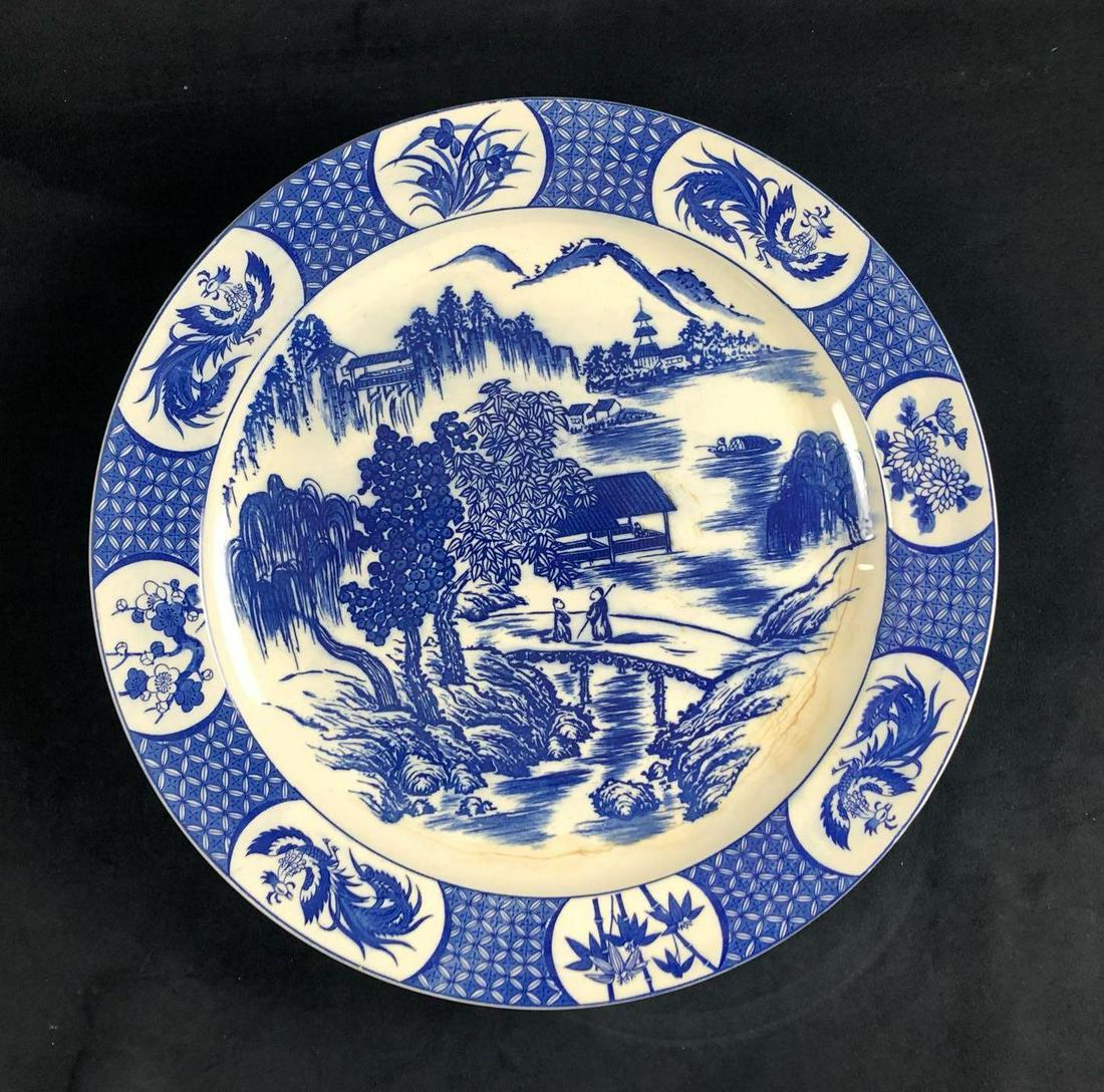 Japanese Ceramic Blue Willow Round Plate: Blue Willow Mid Century Round Plate Serving Platter Japan Ceramic This is a mid-century large blue willow serving platter. This is a large round plate made of ceramic. The scene depicts two people on