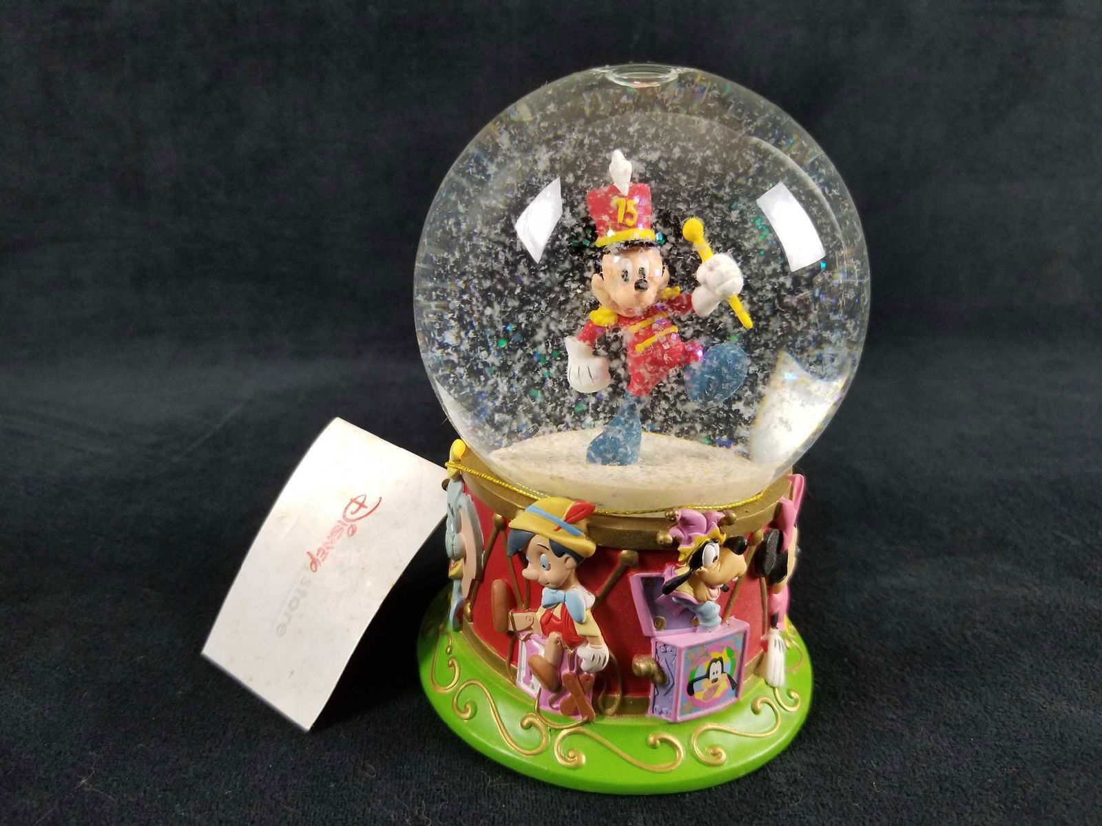 Disney Store Mickey Mouse 75th Anniversary Special: Originally sold at the Disney Store. This snow globe celebrates the Mickey's 75th anniversary. Glass globe shows Band Leader Mickey marching in the globe and a colorful, textured resin base that shows