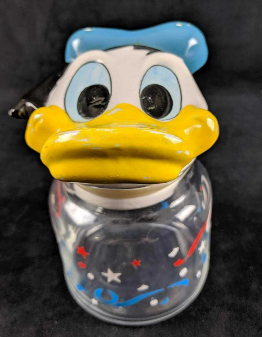 DIsney Vintage Donald Duck Candy Jar: Glass jar with ceramic Donald Duck head. Donald Duck looks up at you and wonders what candy you will have next. Head is missing paint from his bill and hat, which could be easily touched up.Glass jar 