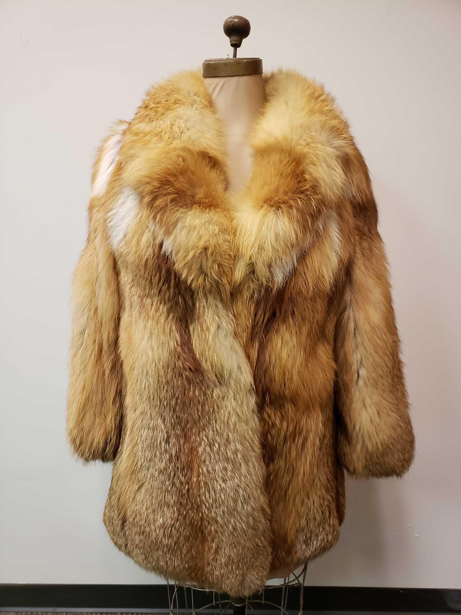 Mid Length Red Fox Fur Coat: Mid Length Red Fox Fur Coat. This fur coat is in great used condition. There is no known damage to the interior or exterior of the coat. The coat has a brown colored fabric lining. Coat has a hook and