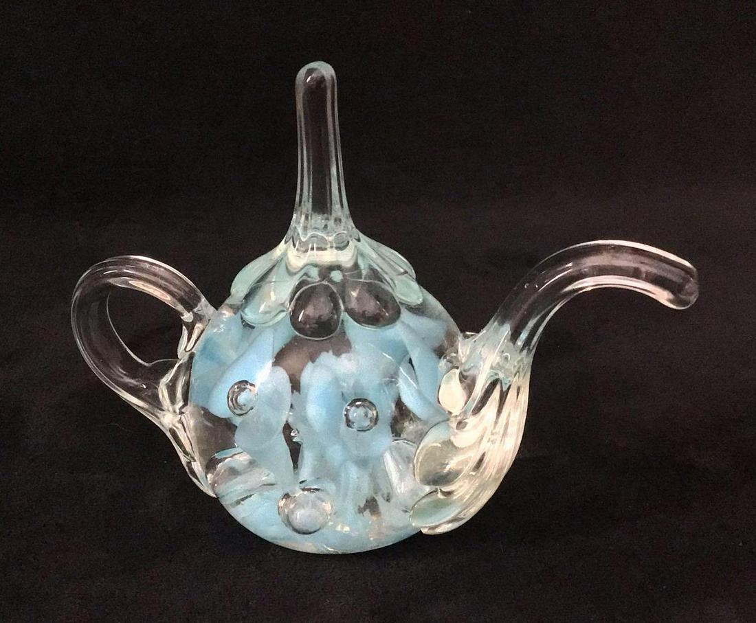Glass Art Teapot Modern Designer Joe Rice Blue: Glass Art Teapot Designer Joe Rice Blue. This is a glass art piece shaped like a teapot that appears to be modern. It has blue floral designs with controlled bubbles. The underside reads "Joe St.Clair