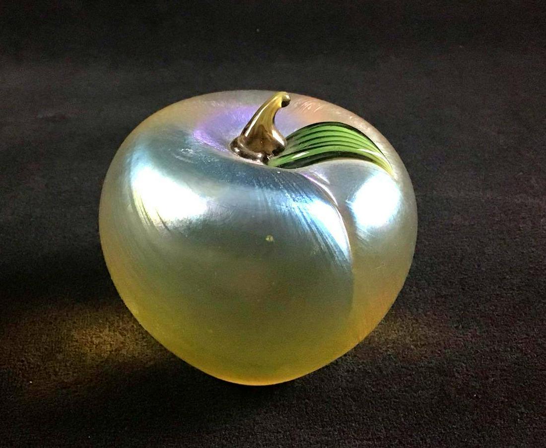 Orient & Flume Glass Paperweight Green Apple: This green apple glass paperweight is made by orient & flume. It has a lovely iridescent finish. You can see the company's logo at the bottom of the piece. The original sticker is still on the bottom