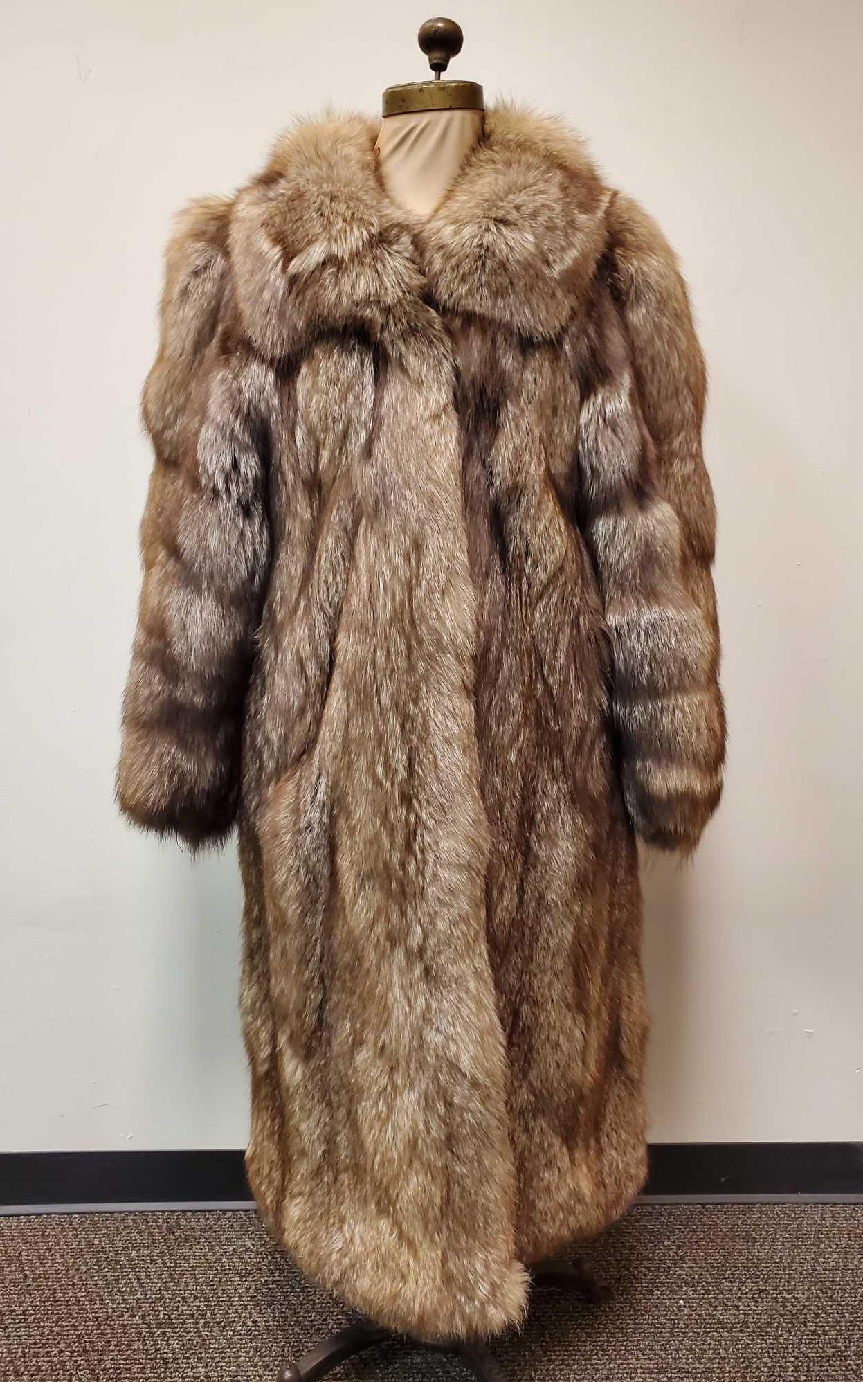 Full Length Brown and Silver Haired Fox Fur Coat: This full length Fox fur coat with brown and silver hues features 2 outside pockets, 3 hook and loops for closure, and dark brown linen interior. This coat is made by an unknown manufacturer. In very