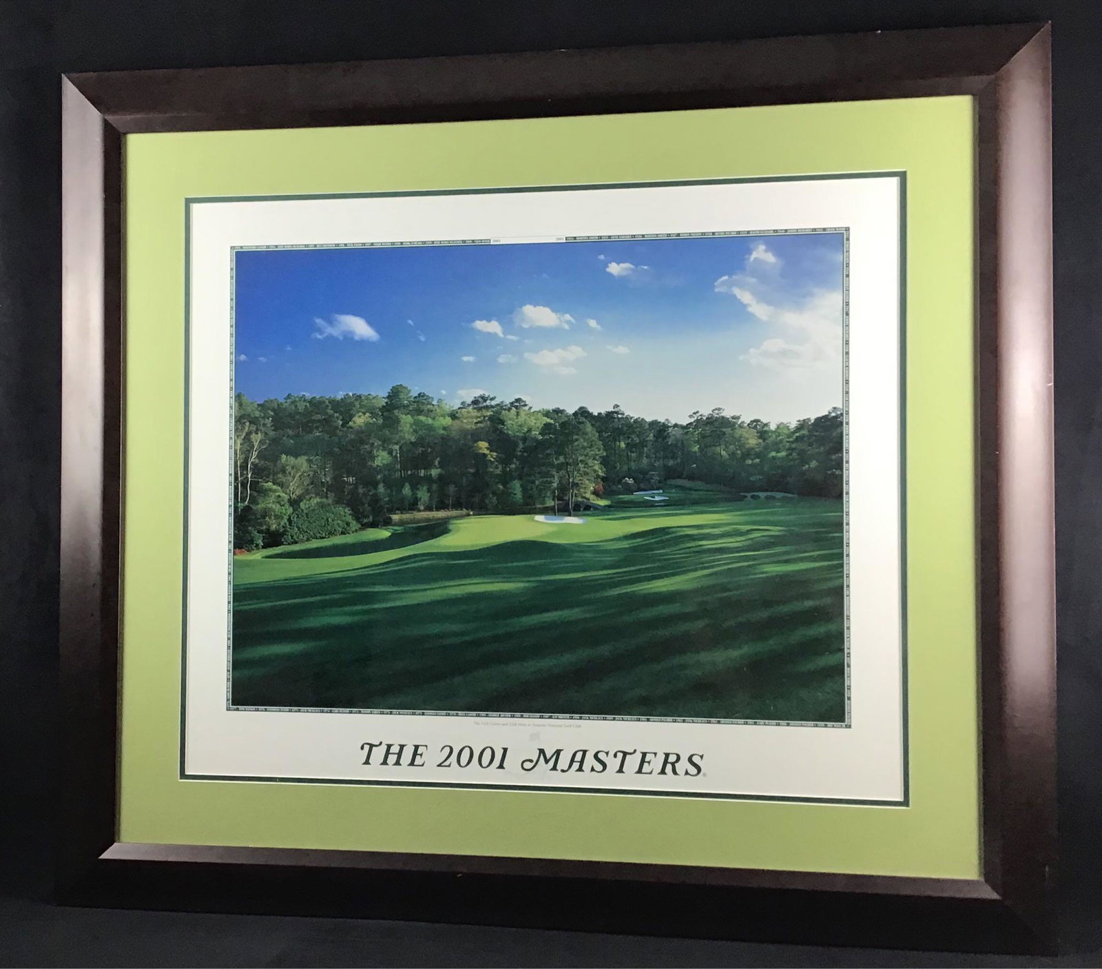 Tiger Woods 2001 Masters Augusta Golf Tournament Poster: Tiger Woods 2001 Masters Augusta Golf Tournament Poster. This is a framed poster depicting the 11th green and 12th hole. The bottom of the poster reads "The 2001 Masters". The photo has the names and 