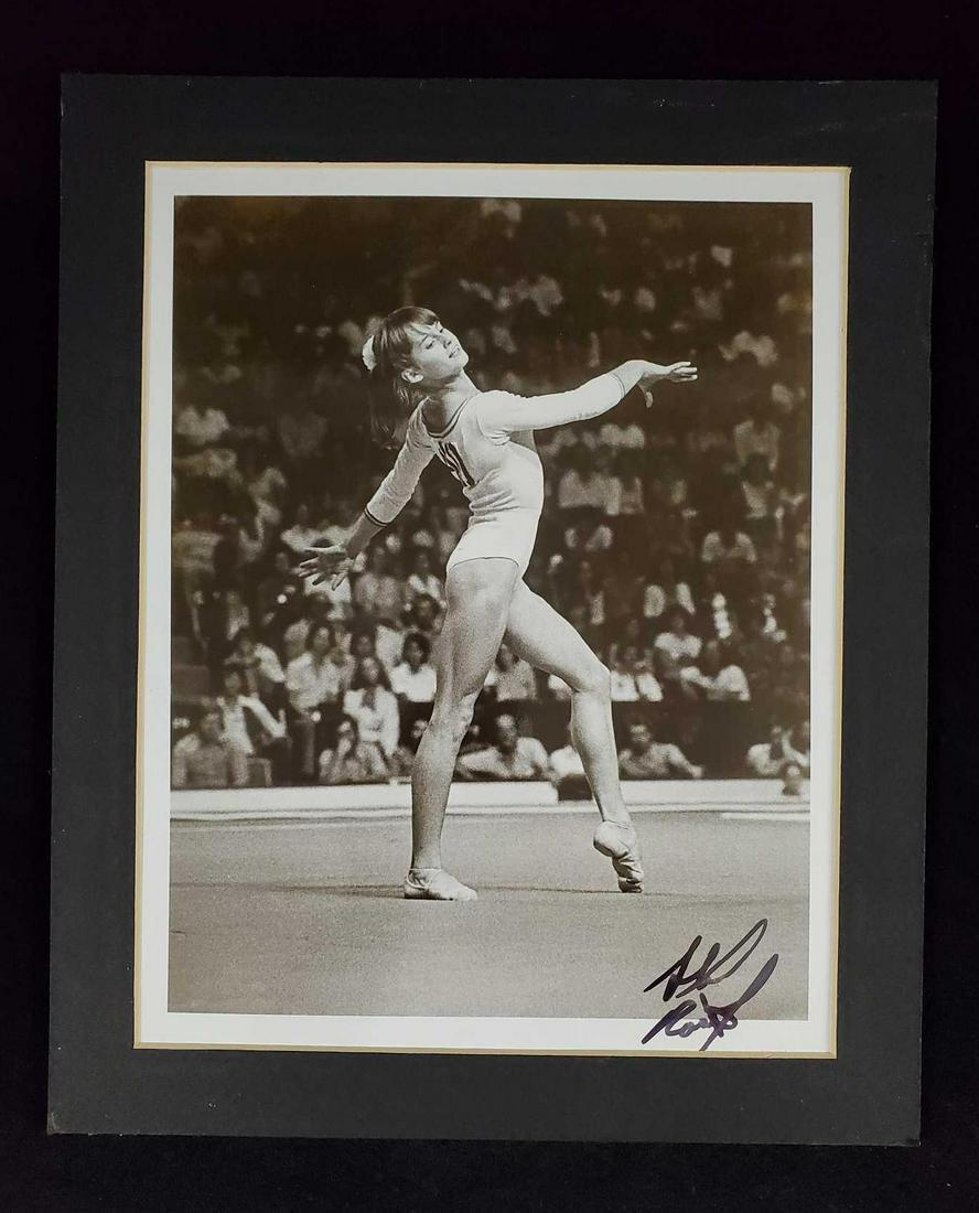 Black And White Matted Photo Of Nadia Comaneci: Black and white photo of an youngÂ Nadia Comaneci doing a routine. Photo is signed, but not by Nadia. Could have been her photographer. Image is approx 7" x "9. Matted image is approx 9Â 1/2" x 1