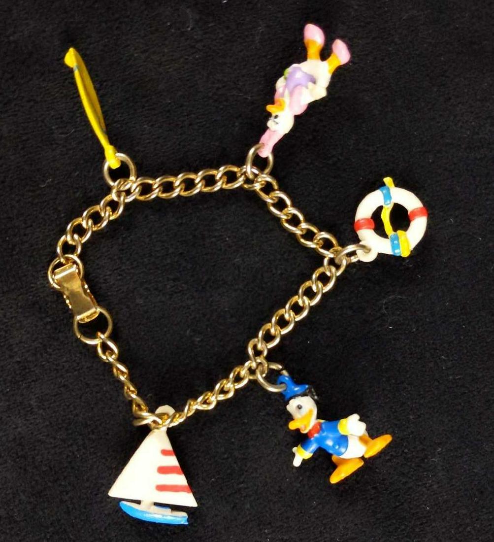 1980s Disney Donald Duck Rubber Charm Nautical Bracelet: 1980's Disney nautical or beach themed charm bracelet featuring Donald , Daisy, sailboat , paddle board /surfboardÂ and a life saver floating device. Bracelet is gold tone and it is in good used co