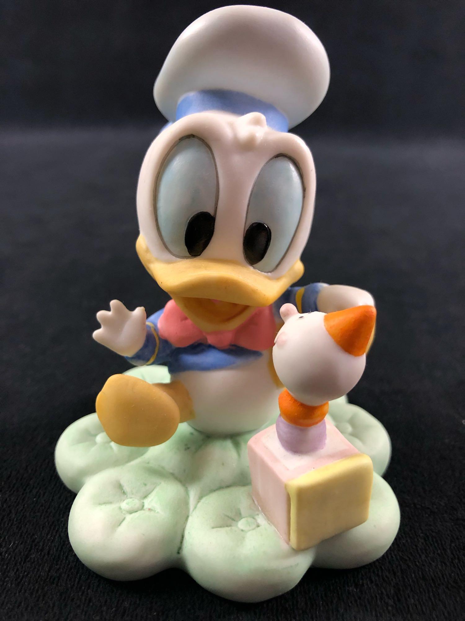 Donald Duck Goebel Disney Babies Donald Duck figurine: Goebel Disney Babies - "Baby's First Smile" Donald Duck figurine. This item is marked under their base with the "Disney Babies" mark, the figurine's name, and "Goebel United States" "Disney". They are