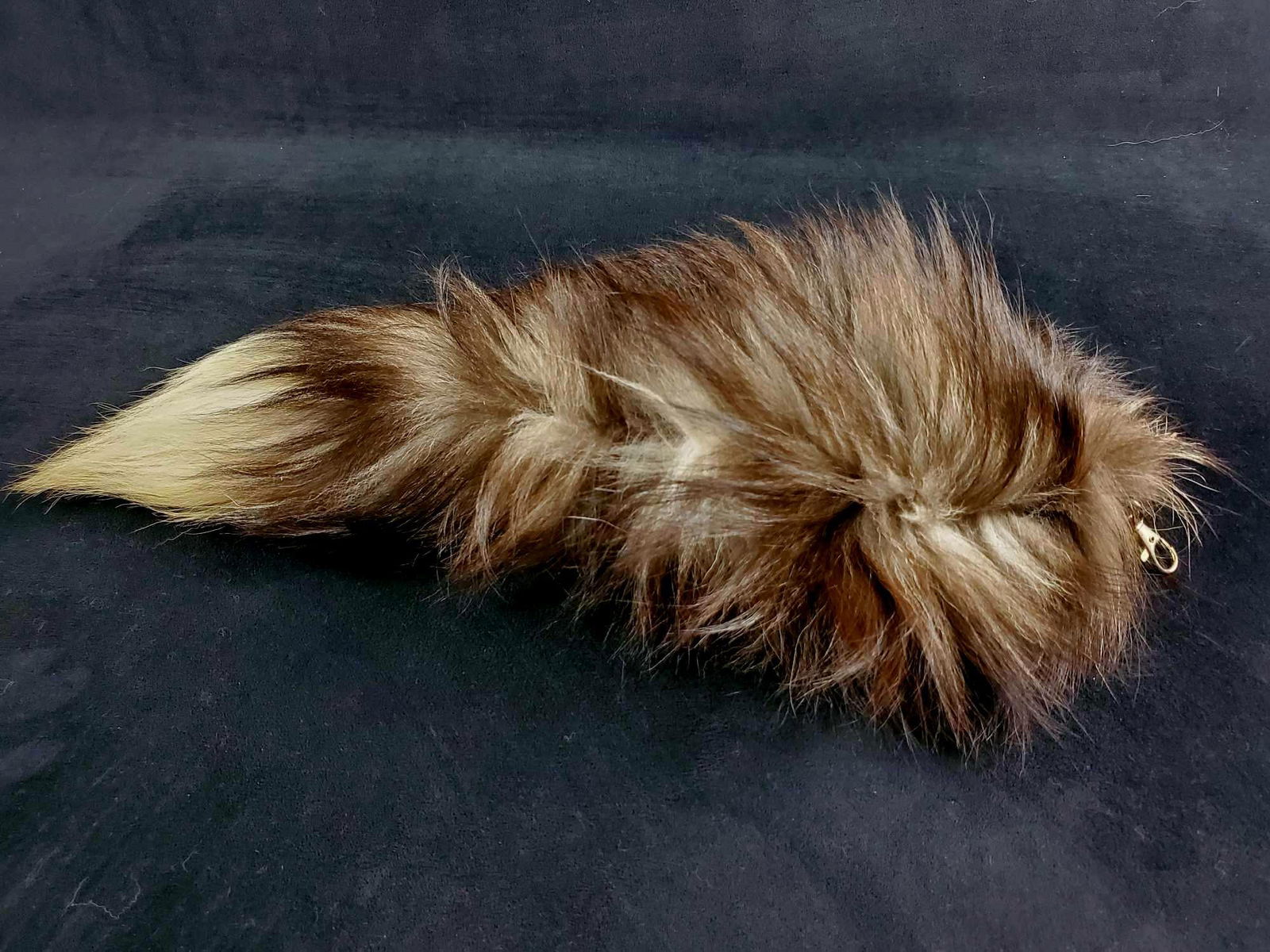 Long Black and White Fox Tail Bag Tassel Keychain: This long plush fox tail bag tassel keychain accessory is black with touches of gray and white. It is made by an unknown manufacturer. It is attached to a black leather piece and a silver tone clasp.