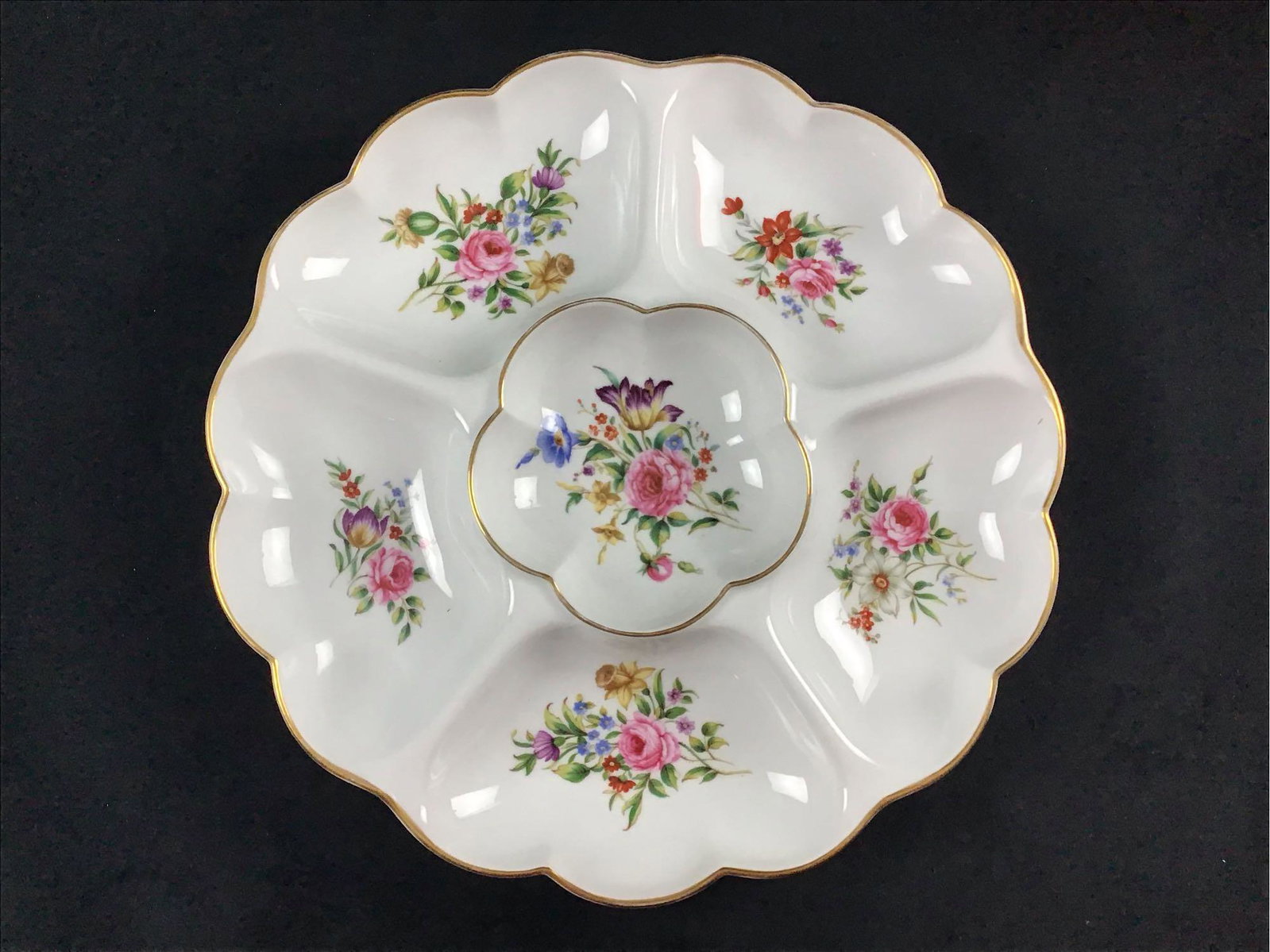 Royal Worcester Vintage Late 1900s Fine Porcelain: This Porcelain piece was made in England by Royal Worcester in the late 1900s. It has colorful floral details in each dip of the plate. The lips have a metallic gold color. This plate is well suited f