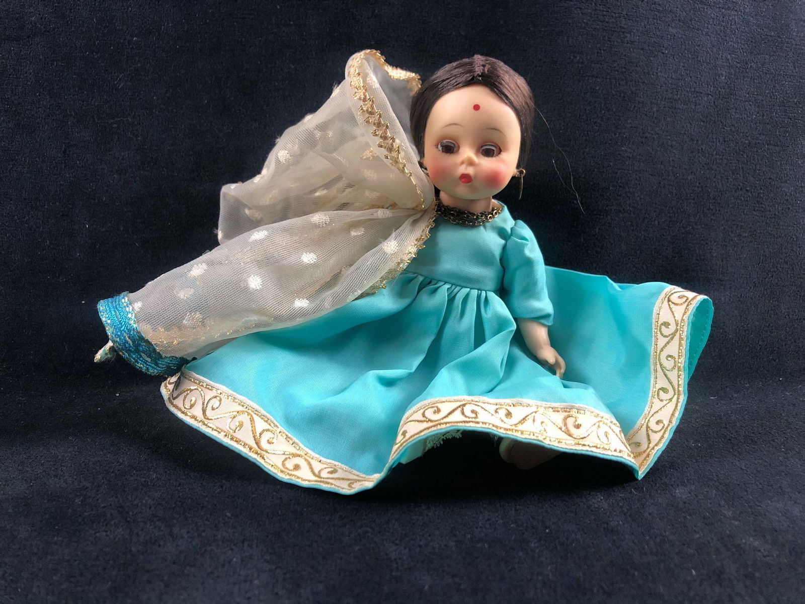 Vintage Madame Alexander Doll India 1965: 1965, Madame Alexander's International Collection - India. This little 8" chestnut-colored hair, brown-eyed beauty is from India. She has a creamy brown complexion with ruby lips and a bindi. She is w