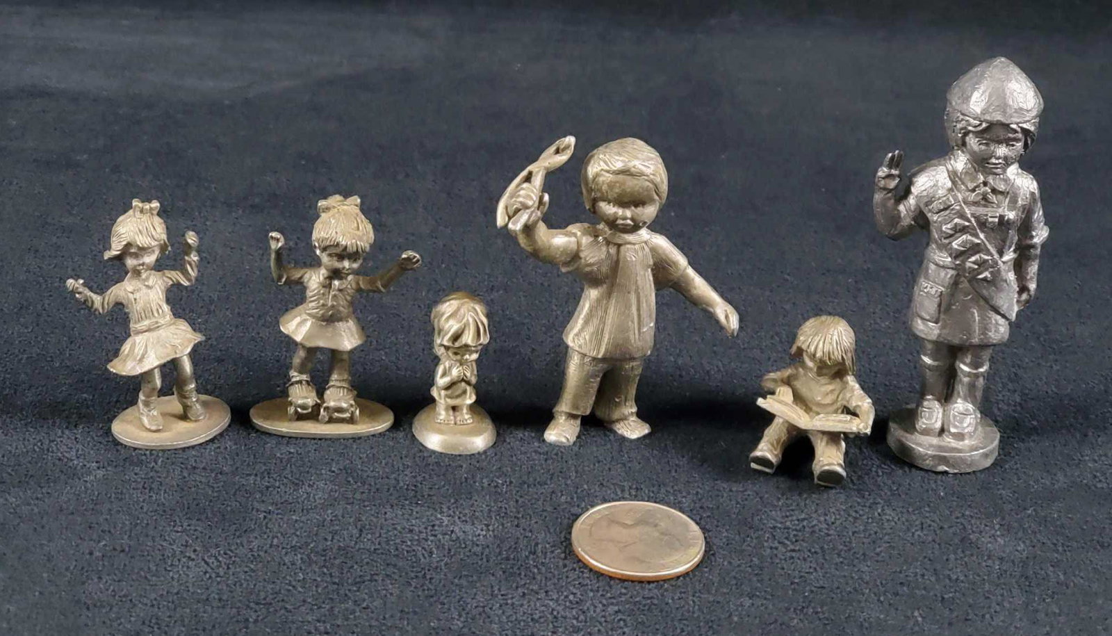 6 Handcrafted Pewter Children Lot: This 6 piece handcrafted pewter lot of children consists of a boy scout, a child reading, an angel praying, a toddler holding up a toy, a dancing girl, and a girl on skates. These pieces are marked an