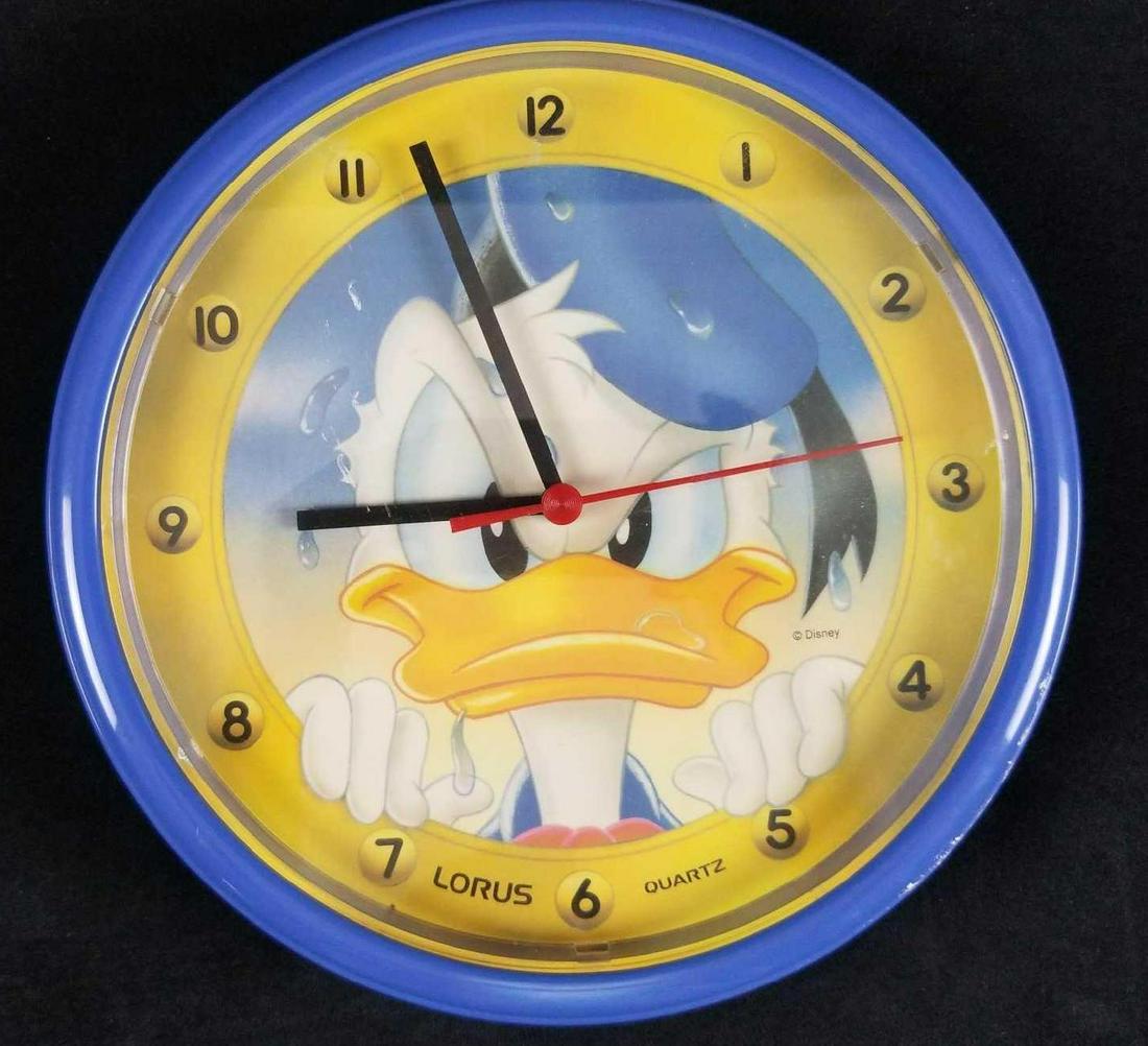 Disney Donald Duck Wall Clock: Donald Duck is cranky on this fun little wall clock by Lorus. Clock is approx 10" across and is tested and working. Requires one AA battery. Clock is in good, used condition with scuffs on the face.