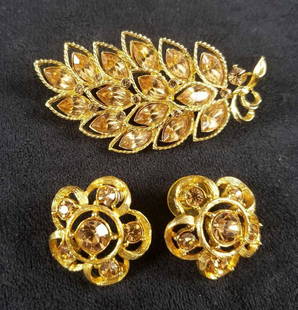 Vintage Gold Toned Flower Brooch and Flower Shaped: This 3 piece lot consists of a gold tone brooch in the shape of a peacocks tail with brown stones and a pair of gold tone earrings in flower shapes with brown stones. The brooch is marked "CM JENT"