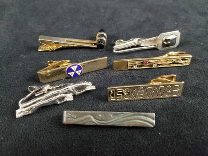 Lot of 7 Vintage Mens Cuff Links Tie Clips: This 7 piece vintage lot of mens cuff links/ tie clips features various designs and consists of:Â (1) Gold tone clip with the letters "P.T.A" in triangular shapes. Unknown manufacterur and date.