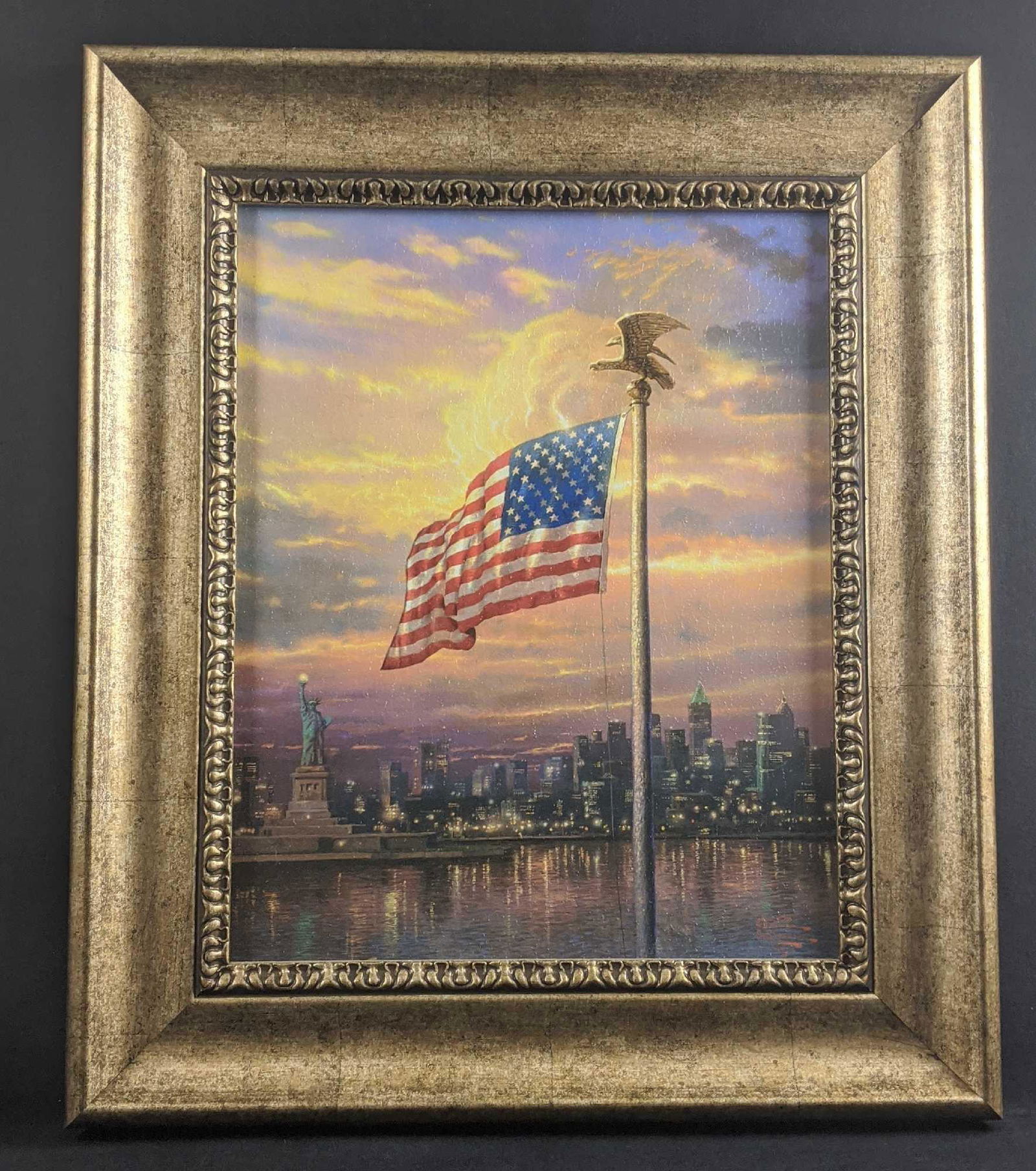 Framed Thomas Kinkade Light Of Freedom New York B: Framed Thomas KinkadeÂ "The Light Of Freedom" Brushstroke Vignette of "The Light Of Freedom". Shows the American Flag with New York and the Statue Of Liberty in the background. It comes with a tope