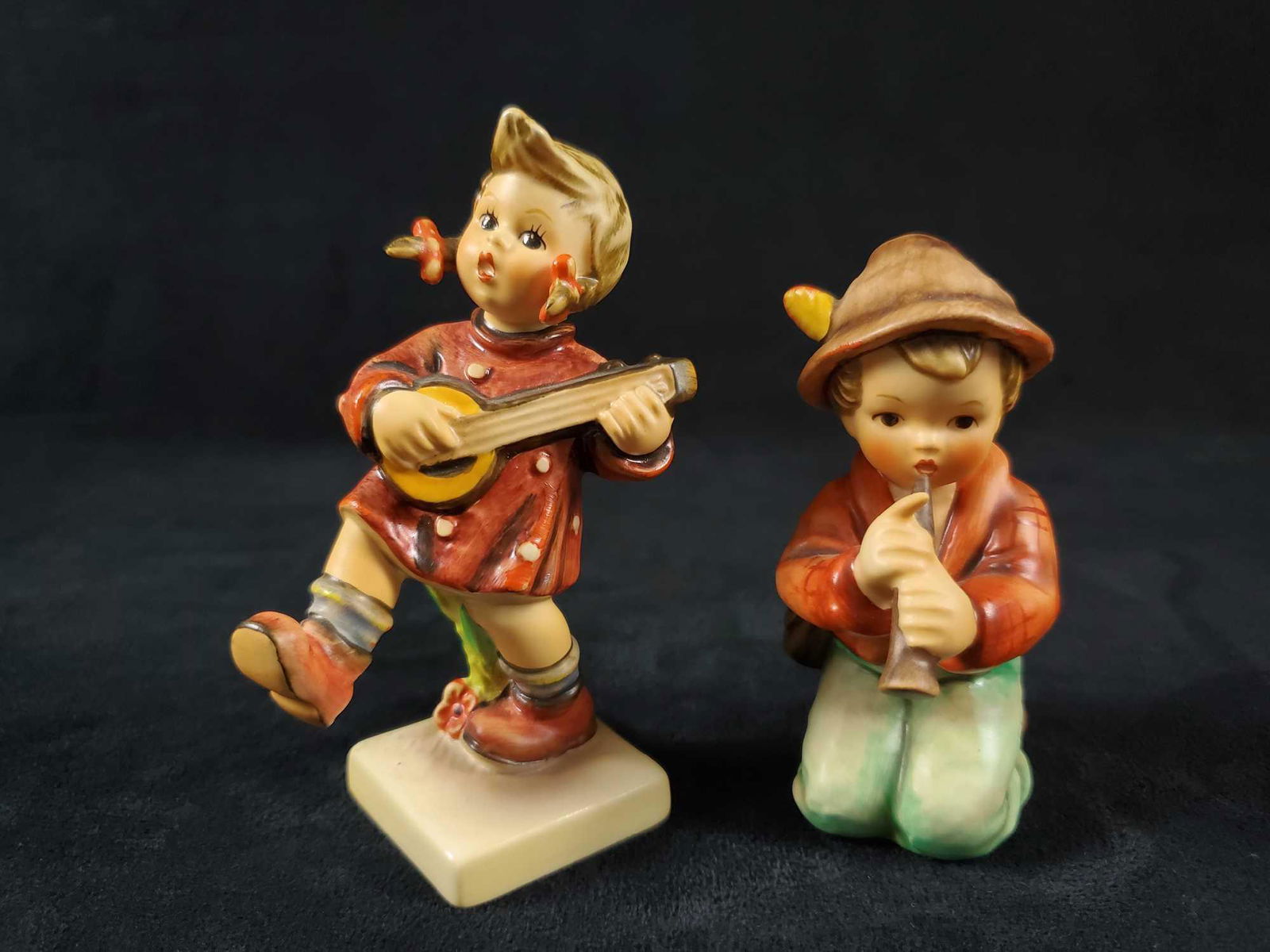 Hummel Goebel Figurine Happiness And Little Tooter: This lot includes: (1) "Happiness" HUM 86. Among the most joyful of M.I. Hummel motifs, this musician was crafted in 1938 by Master Sculptor Reinhold Ung. POM 86. 2" x 3" x 4". Figure is in good, vint