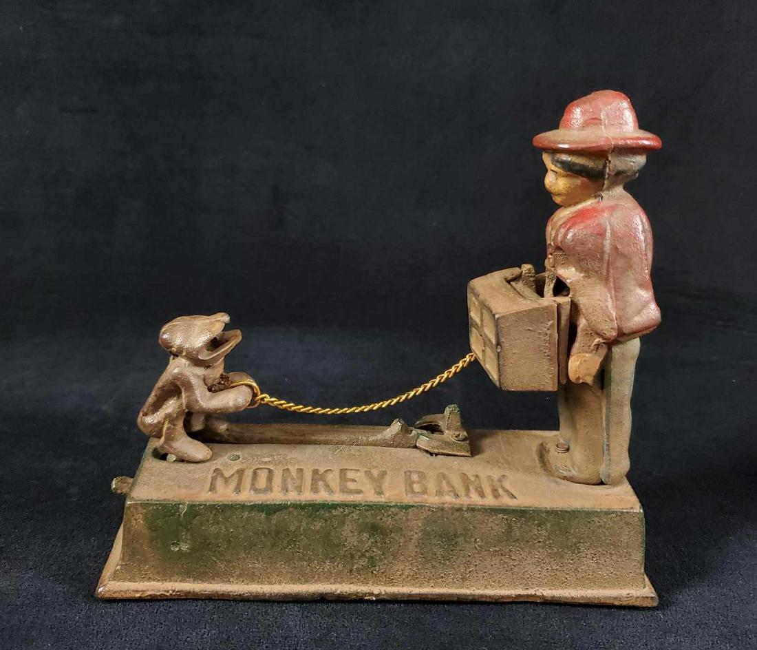 Vintage Cast Iron Monkey Bank W Organ Grinder: Vintage cast iron monkey bank with organ grinder. Feed the monkey a coin, push down the lever and watch the monkey give the organ grinderÂ your coin! Good monkey!Â Bank is in good, vintage condit