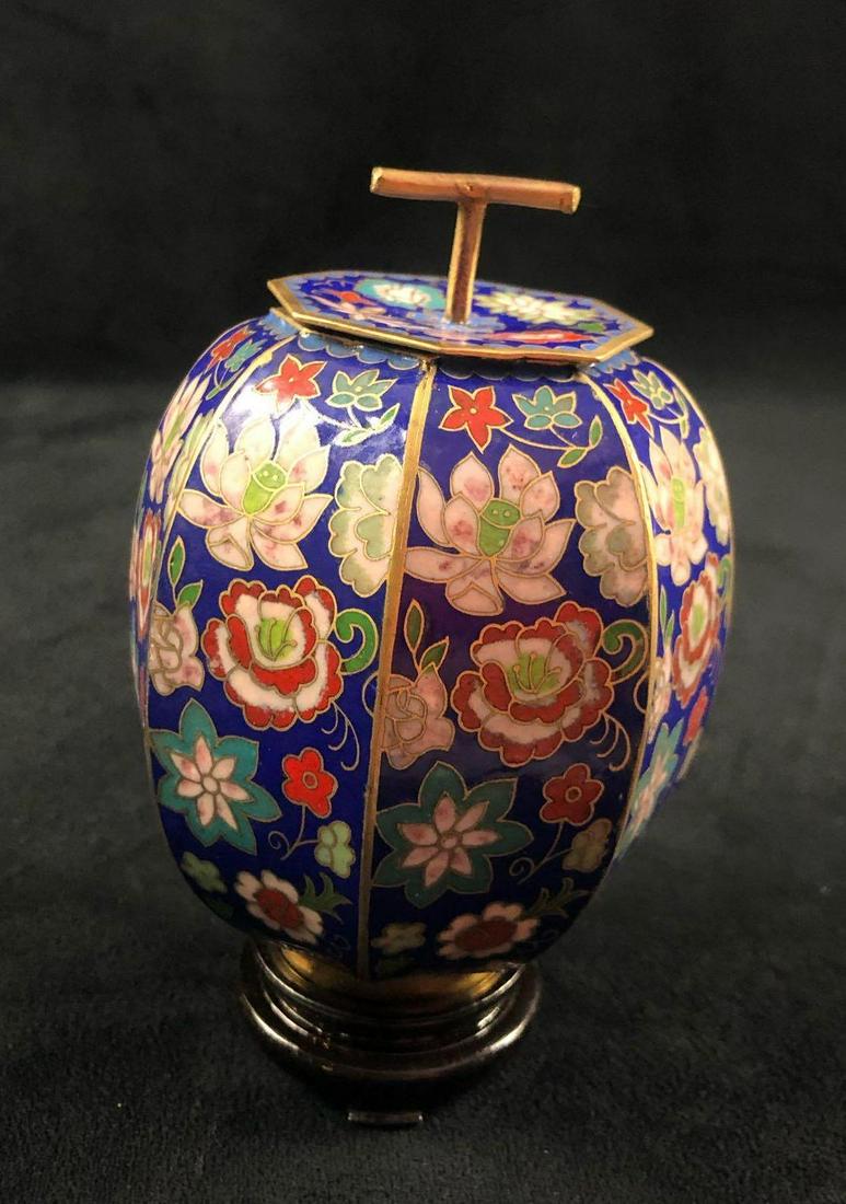 Chinese Art Egg Ornament Cloisonne Vase: This is a Chinese cloisonne egg with a stand. The cap of the egg is removable. The decorative flowers surround the egg-shaped vase. Made of metal and enamel. There are no known chips or cracks. The bo